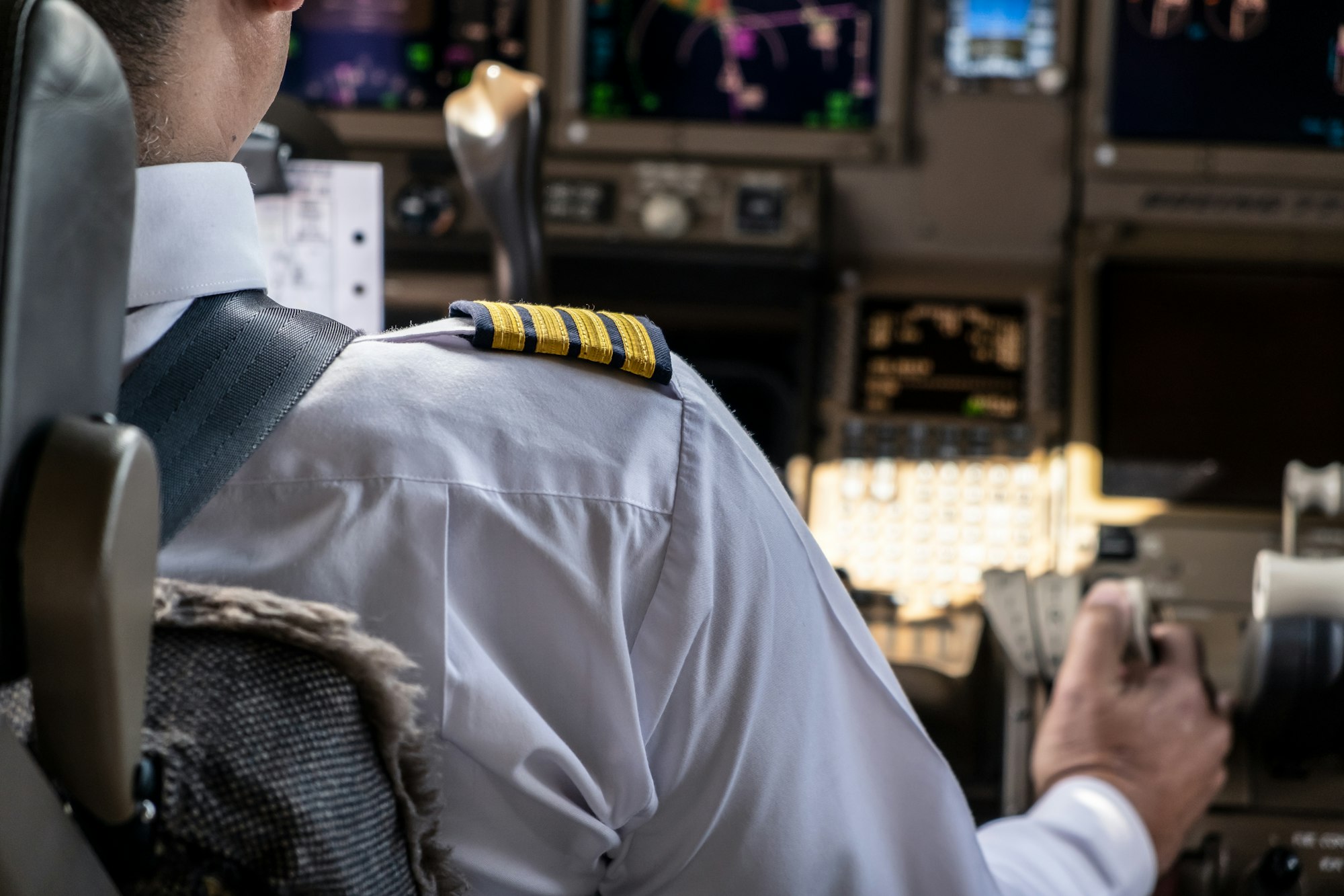 Airliner captain controlling airplane in cockpit.