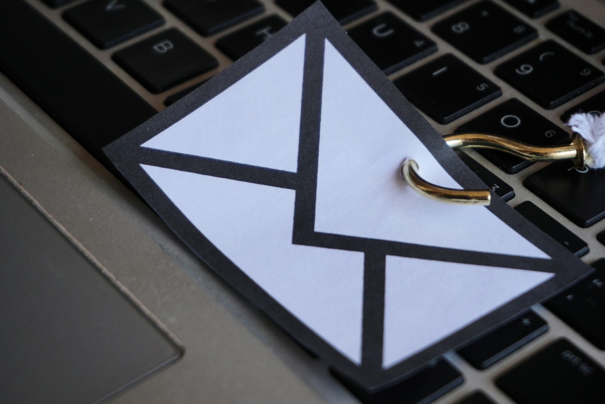 Closeup image of mail with hook on top of keyboard.